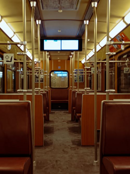 Free Interior of an empty subway car with brown seats and overhead lighting in a modern setting. Stock Photo