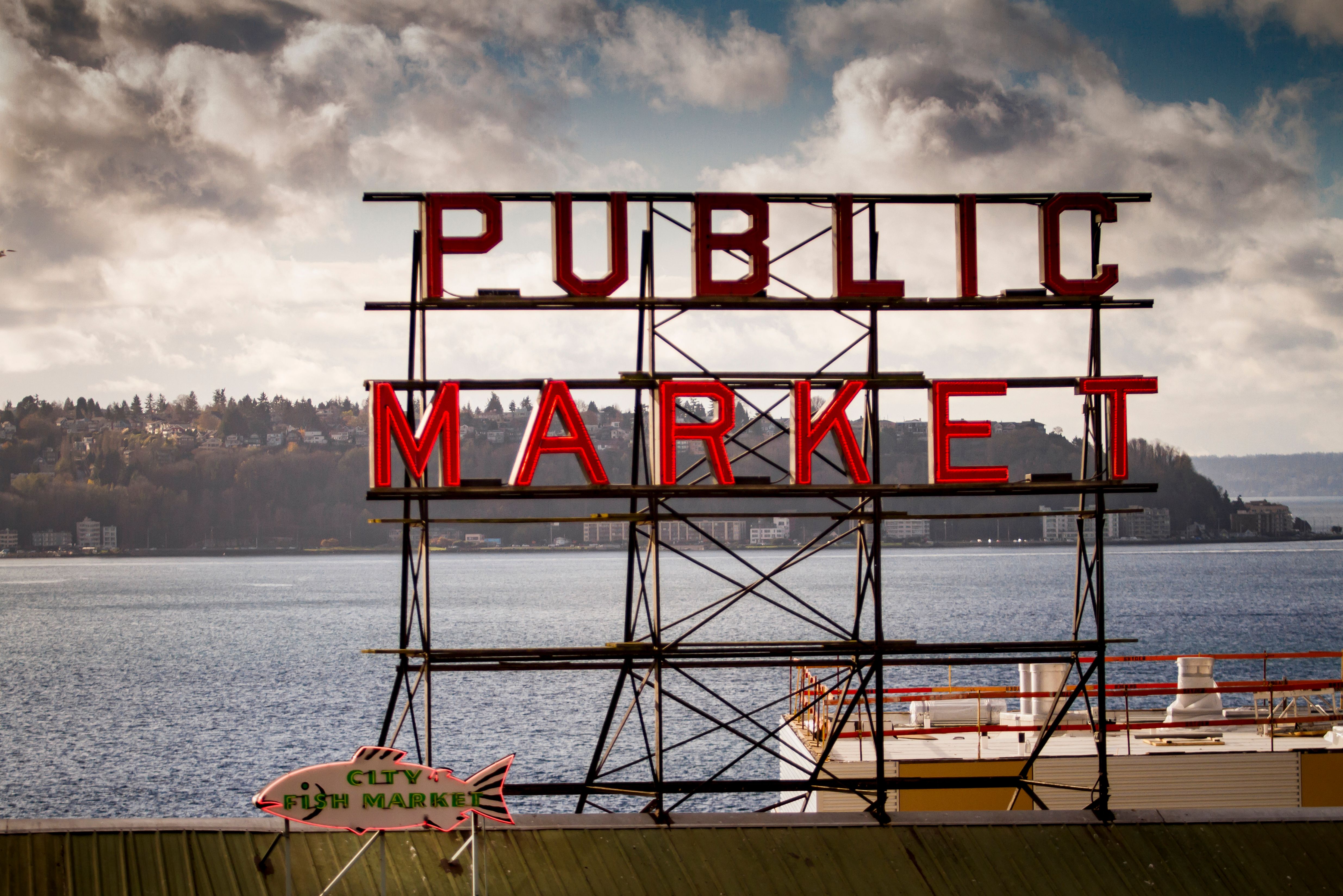 Iconic Public Market sign at Seattle's Pike Place with water view. Iconic Public Market sign at Seattle's Pike Place with water view.