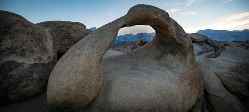 Free A striking natural stone arch formation in Alabama Hills with mountain backdrop at sunrise. Stock Photo