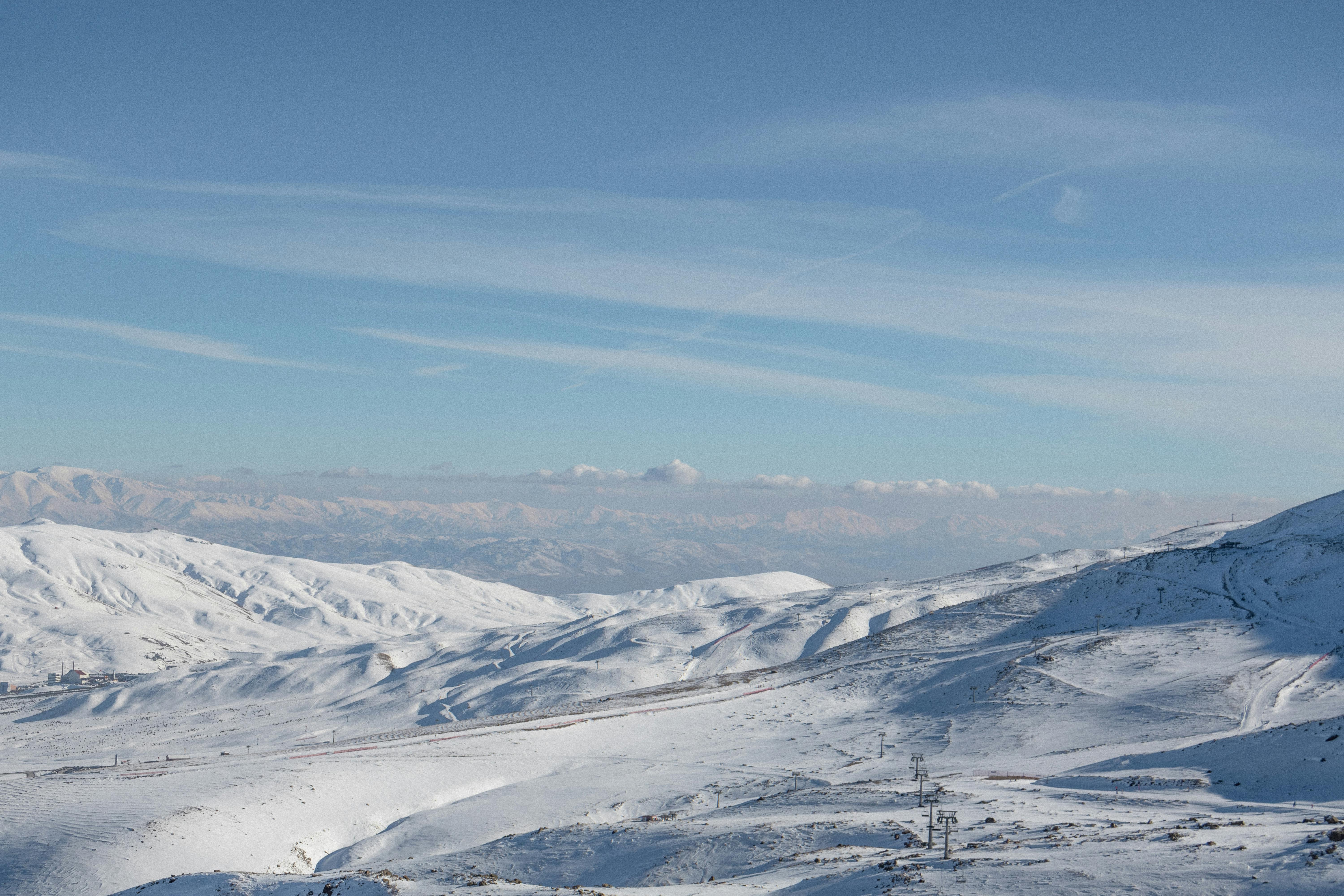 Gratis Una vista panoramica delle montagne innevate sotto un cielo azzurro e limpido. Foto a disposizione