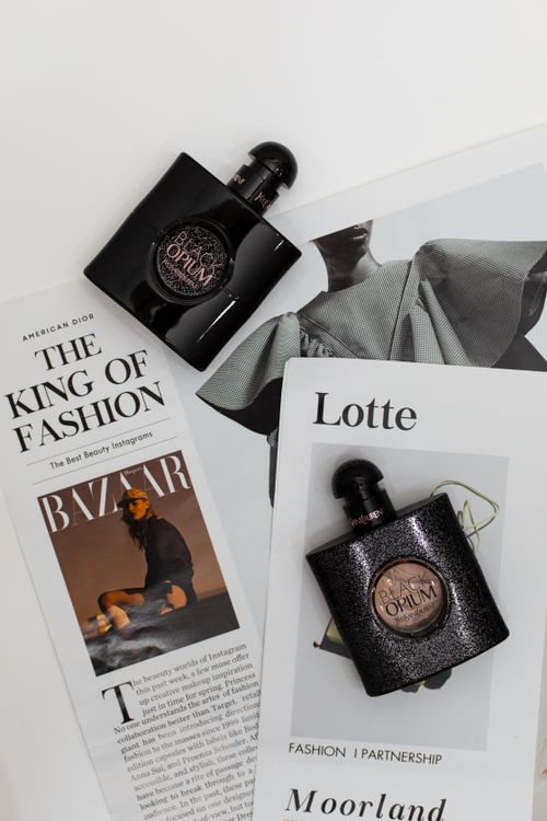 Free Elegant flat lay featuring Opium perfume bottles on fashion magazines. Perfect for luxury and style themes. Stock Photo