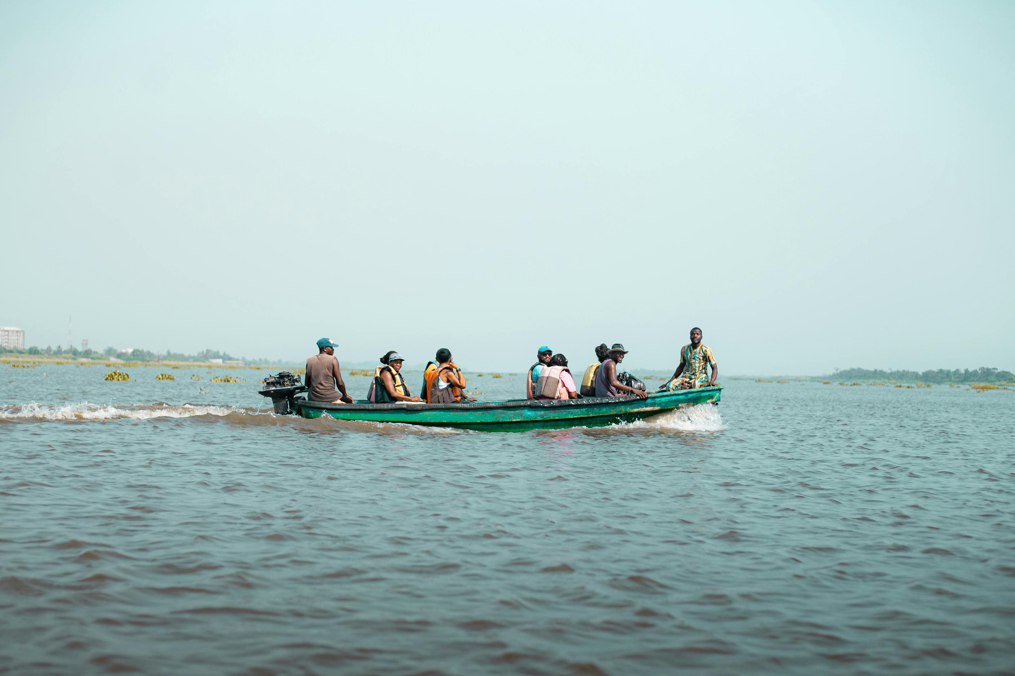 Free A group of people navigate a traditional boat on Badagry Lagoon, Nigeria. Stock Photo