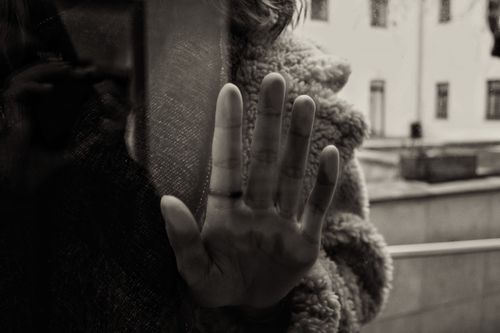 Free A moody black and white photo of a hand touching glass with a reflection. Stock Photo