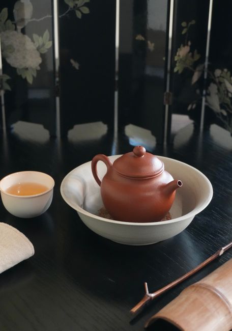 A beautifully arranged ceramic teapot and tea cup set on a classic table setting.