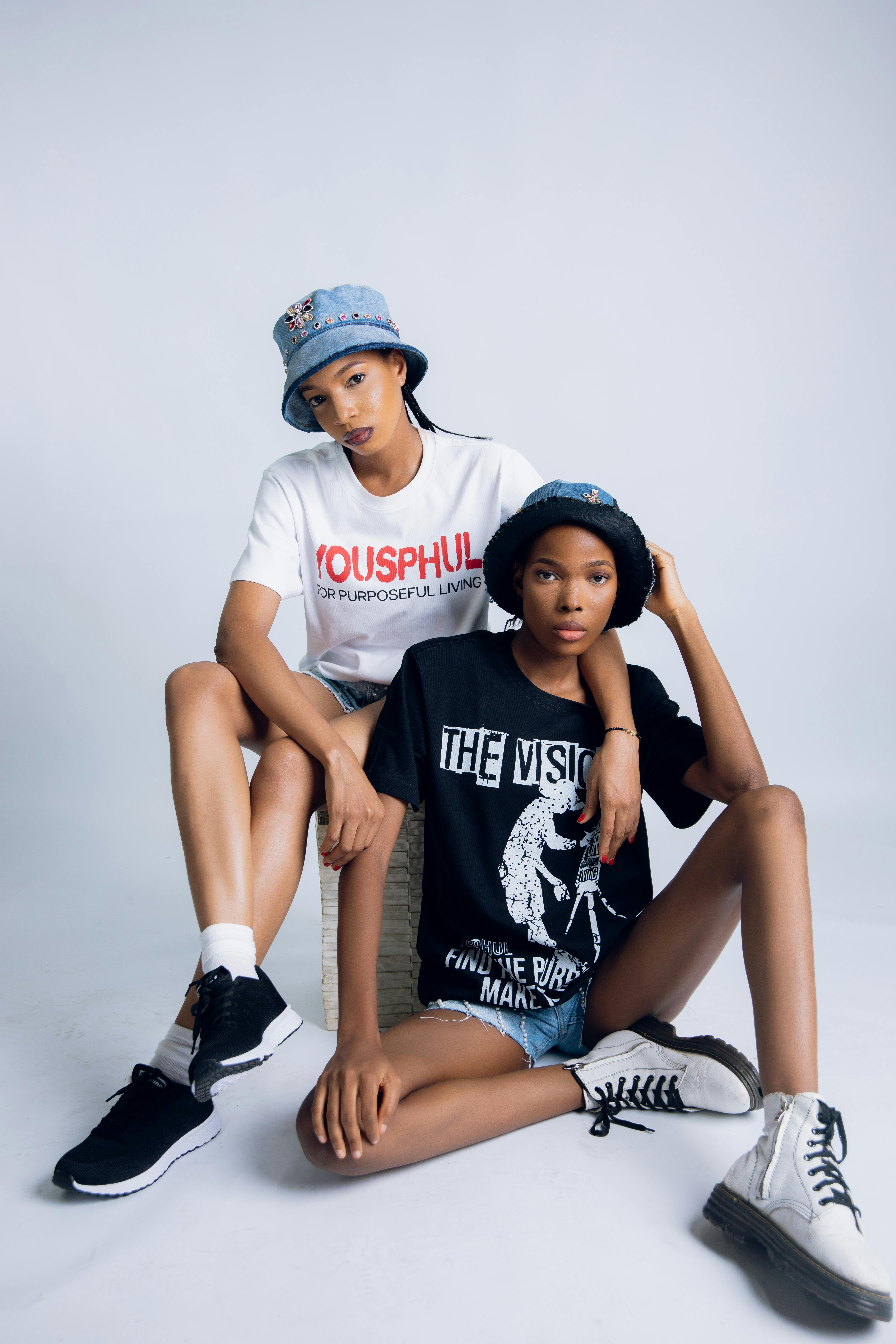 Trendy urban youth wearing casual t-shirts and bucket hats in a studio setting.