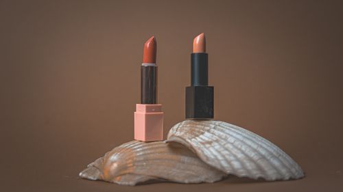 Free Two elegant lipsticks displayed on a seashell with a minimalist, earthy backdrop. Stock Photo