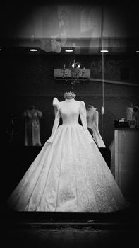 A stunning wedding dress with intricate details displayed in a boutique window, exuding elegance and style.