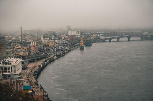 Free A misty aerial view of Kyiv city along the Dnieper River, showcasing iconic architecture and bridges. Stock Photo