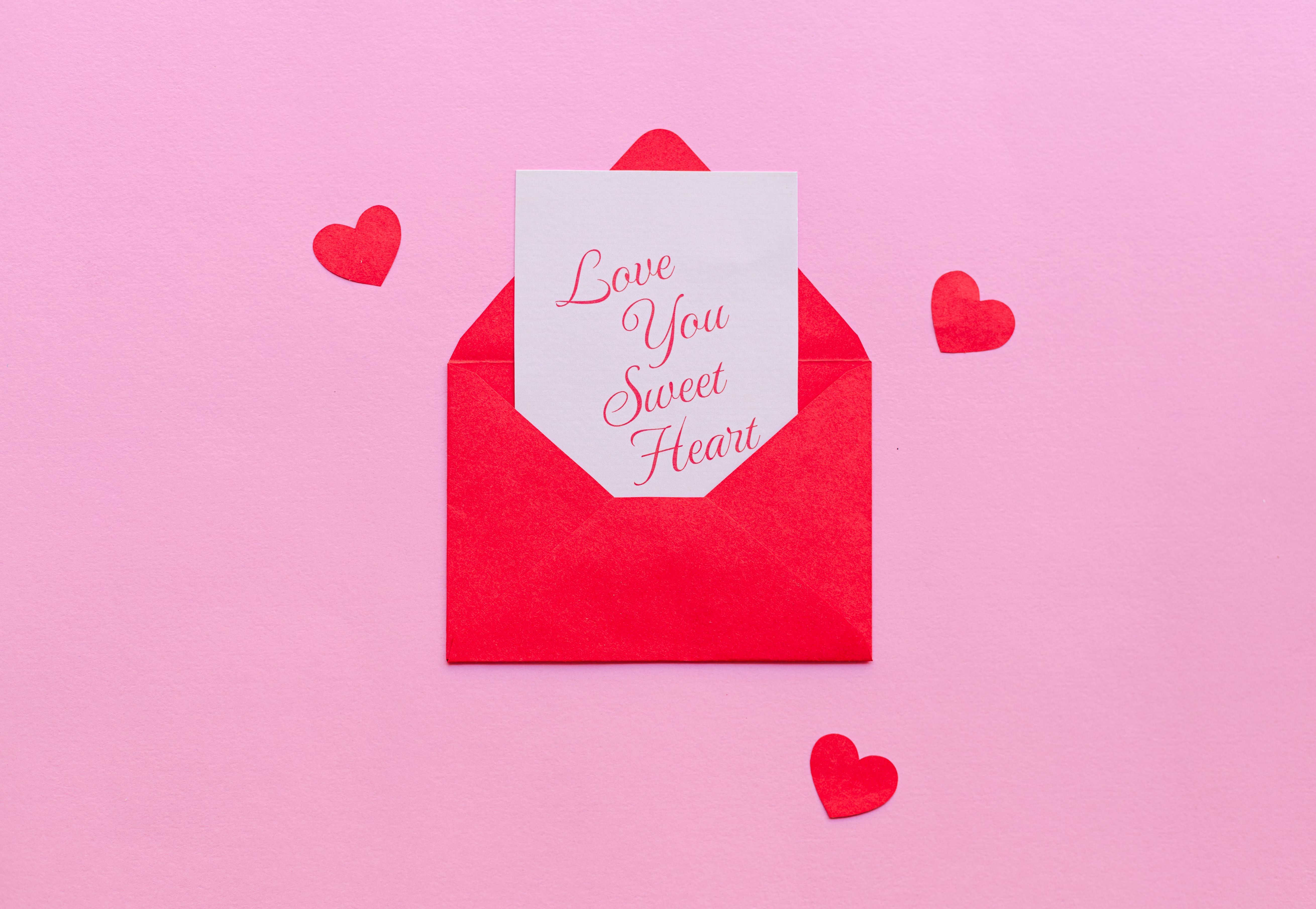 Gratuit Un plic rosu cu o scrisoare de dragoste pe fundal roz, ideal pentru Valentine's. Fotografie de stoc