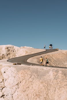 一群人走在蜿蜒的小路上，穿过阳光明媚的干旱沙漠