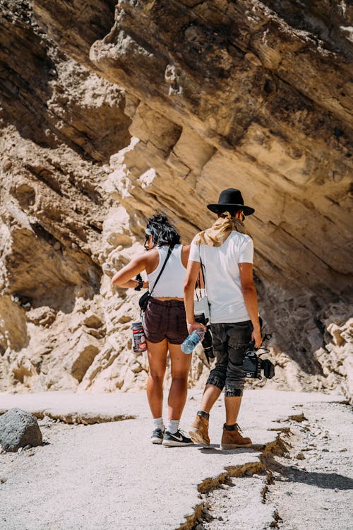 People Standing near a Rock