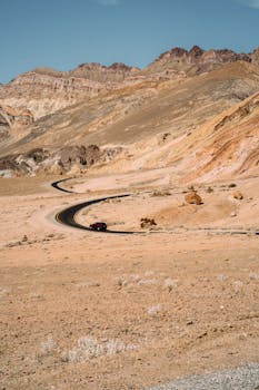 晴朗的天空下，蜿蜒的道路穿过沙漠，风景如画
