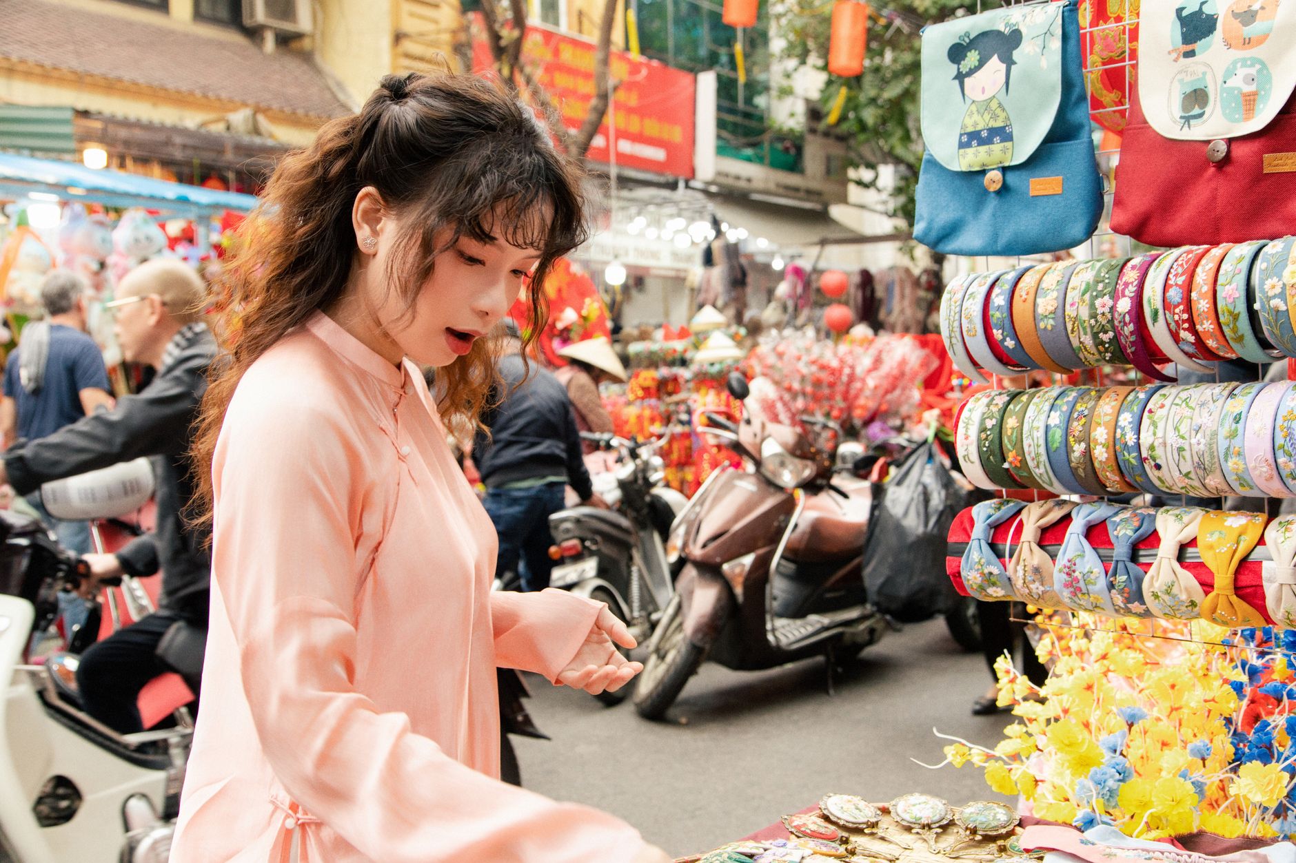 A woman browses items at a bustling Hanoi market during Lunar New Year celebrations.
