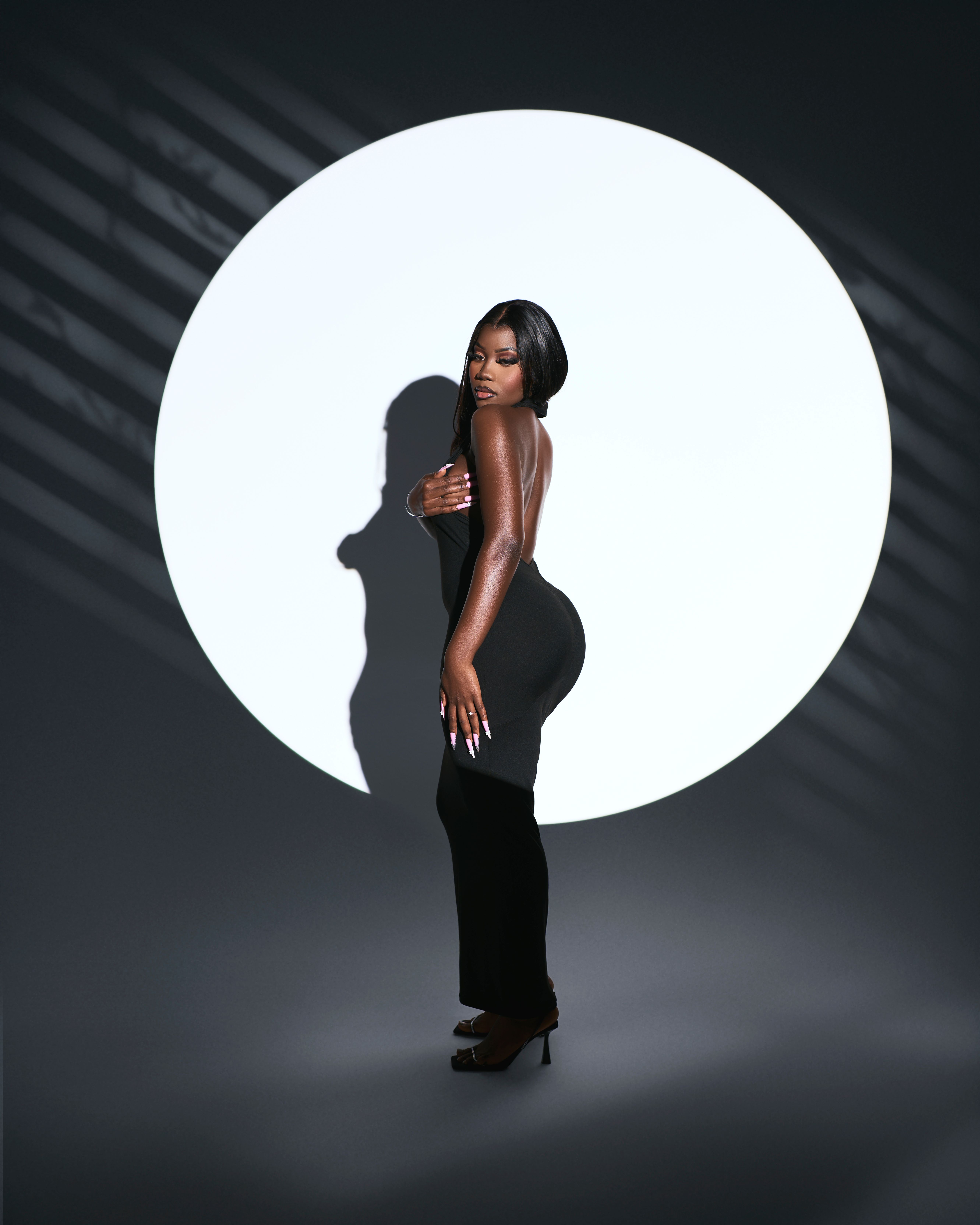 Elegant Woman in Black Dress with Dramatic Shadow  Free Stock Photo