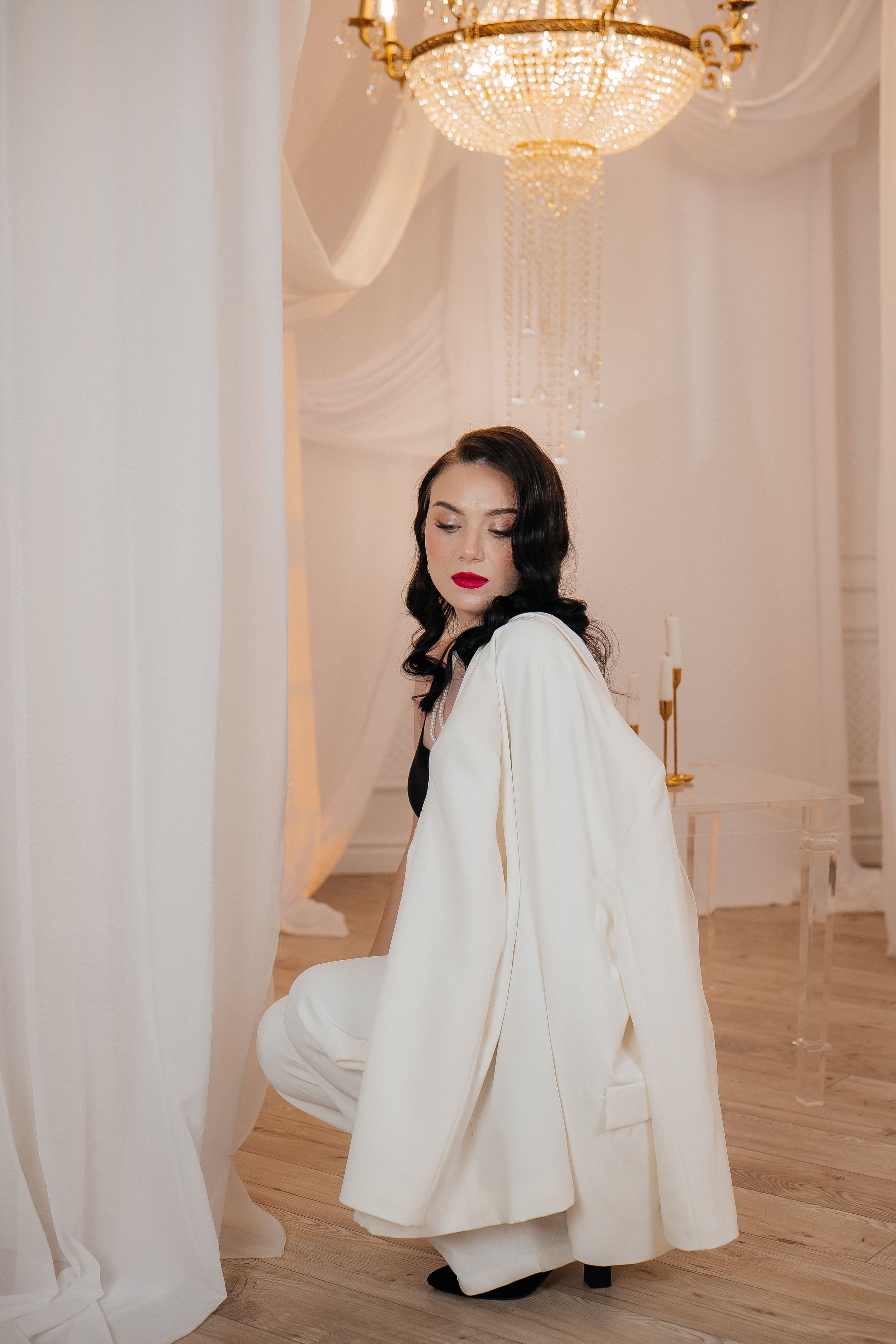 Elegant Woman in White Outfit with Chandelier · Free Stock Photo