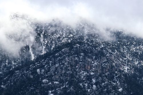 Free Snow-covered mountains shrouded in fog in Antalya, Türkiye, depicting winter's beauty. Stock Photo