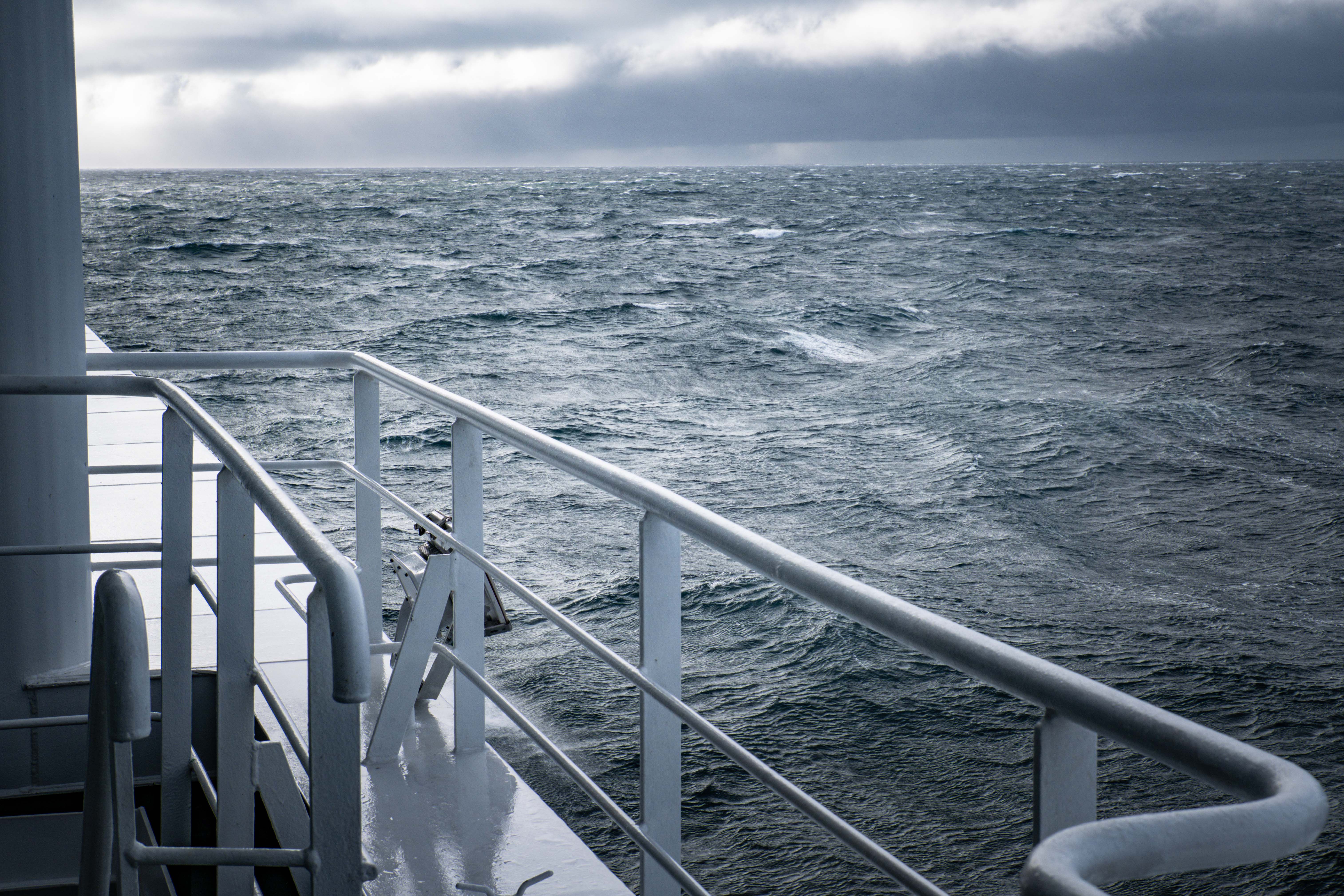 Dramatic sea view during stormy weather from a ship's deck, showcasing turbulent waters.