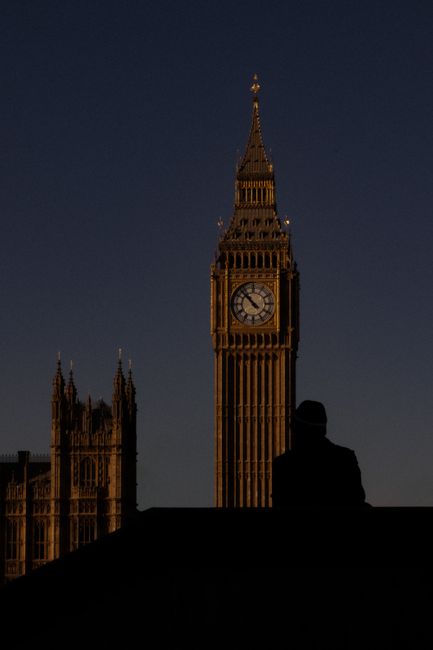 A dramatic silhouette of Big Ben against a dark evening sky in London, England.