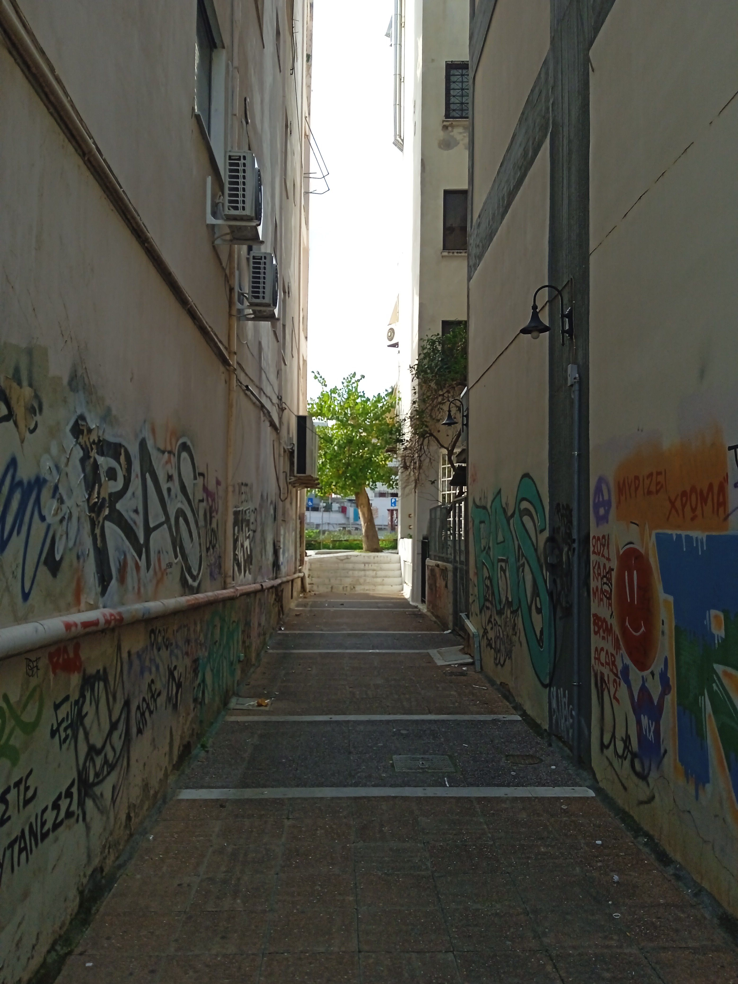 Alley with colorful graffiti in Kalamata, Greece, showcasing urban street art.