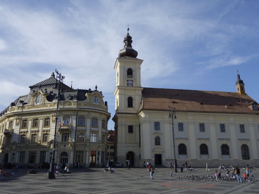 View of the historic Great Square in Sibiu, featuring iconic architecture under a clear blue sky.