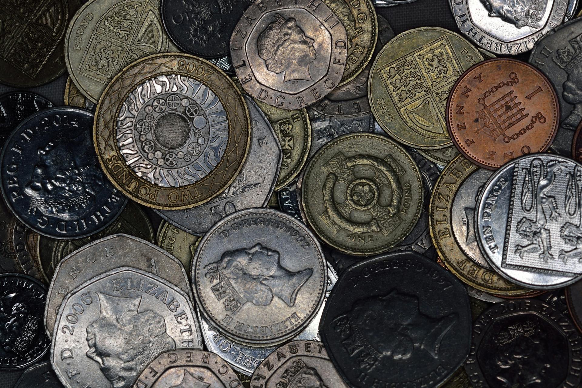 Close-up image of various British coins showing diverse designs and denominations.