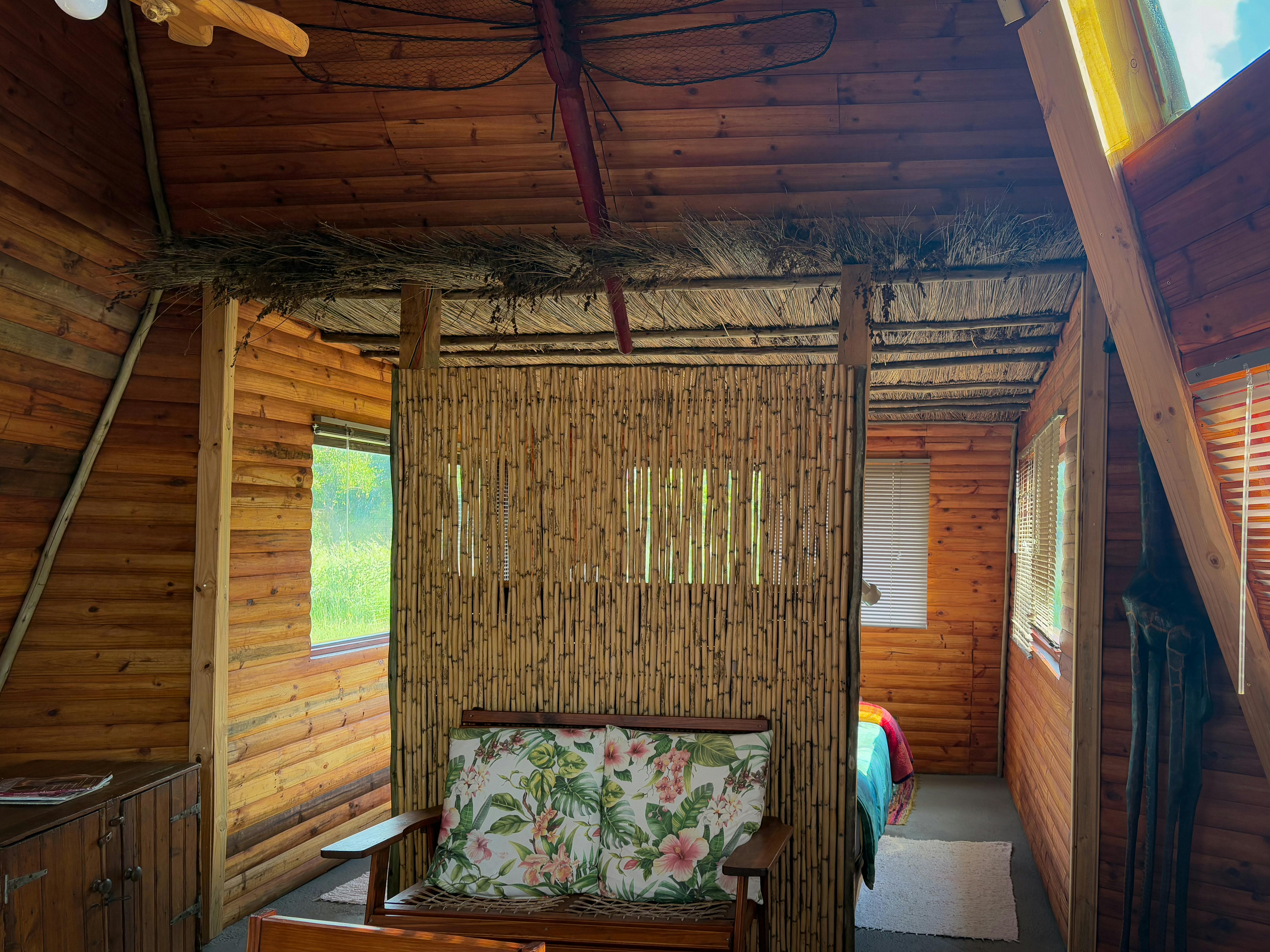 Intérieur chaleureux de cabine en bois avec un décor rustique en bambou et des accents floraux.