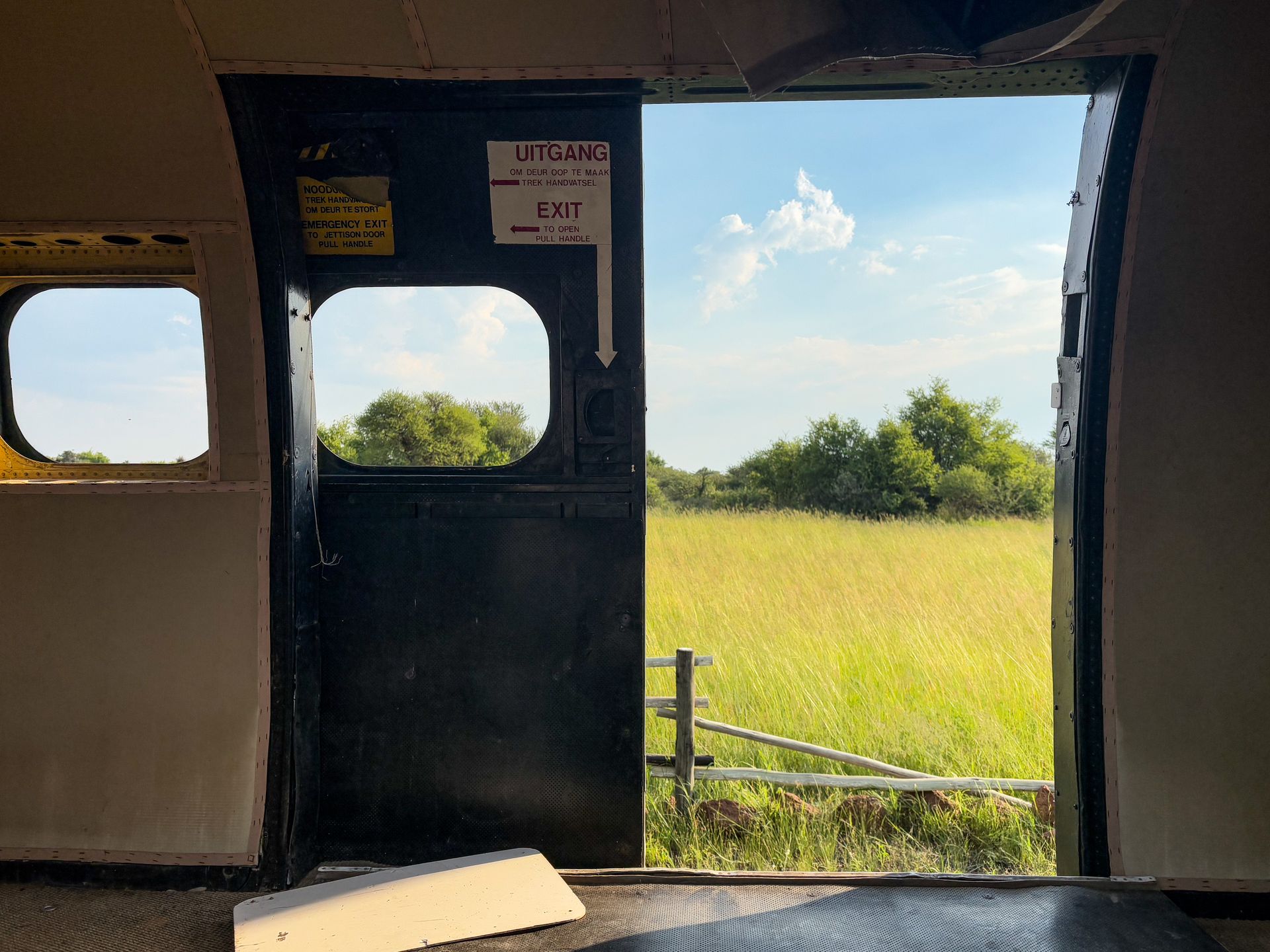 View from inside an old helicopter looking into lush grassland.