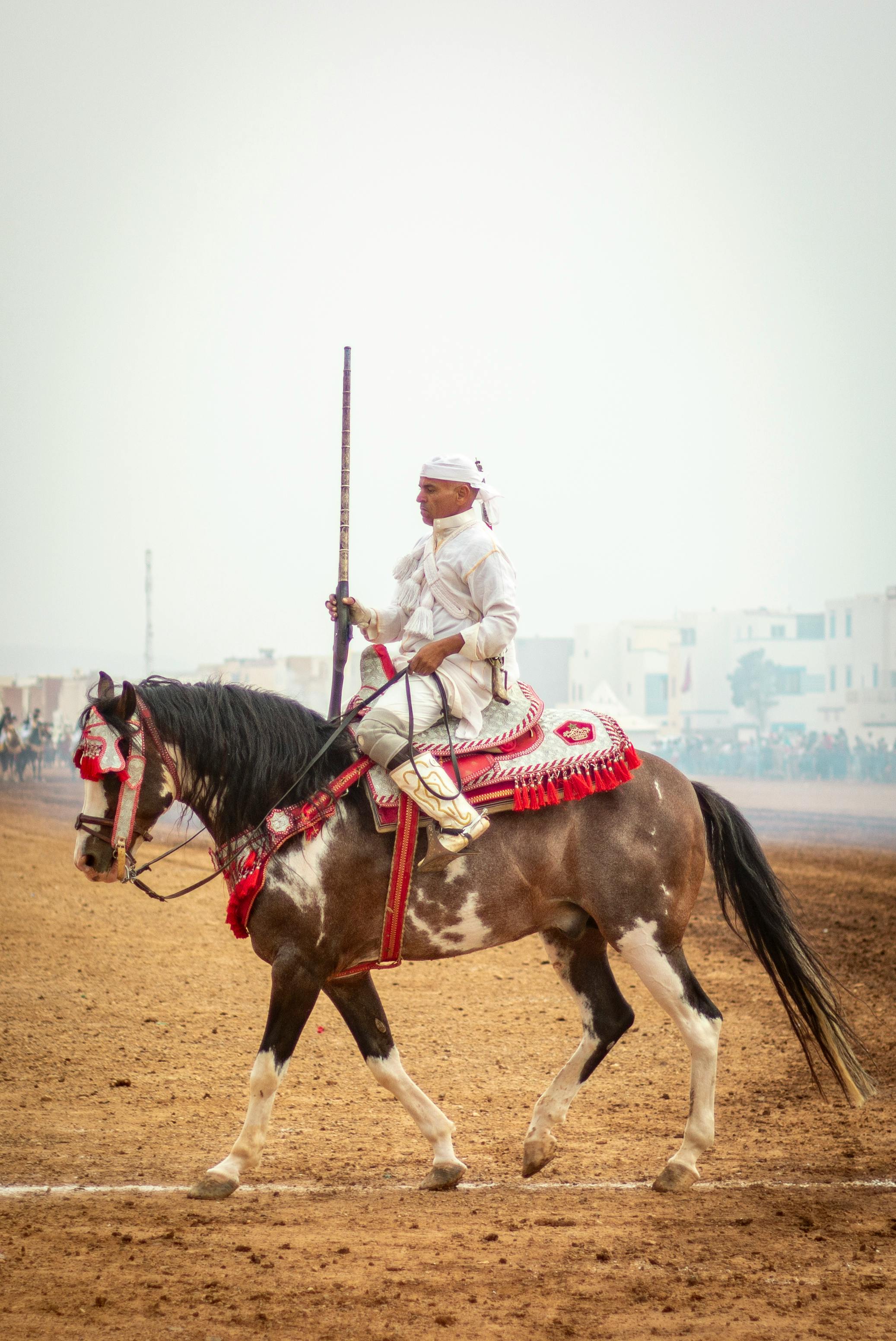 A horse rider participating in a traditional equestrian event on an ornate horse.