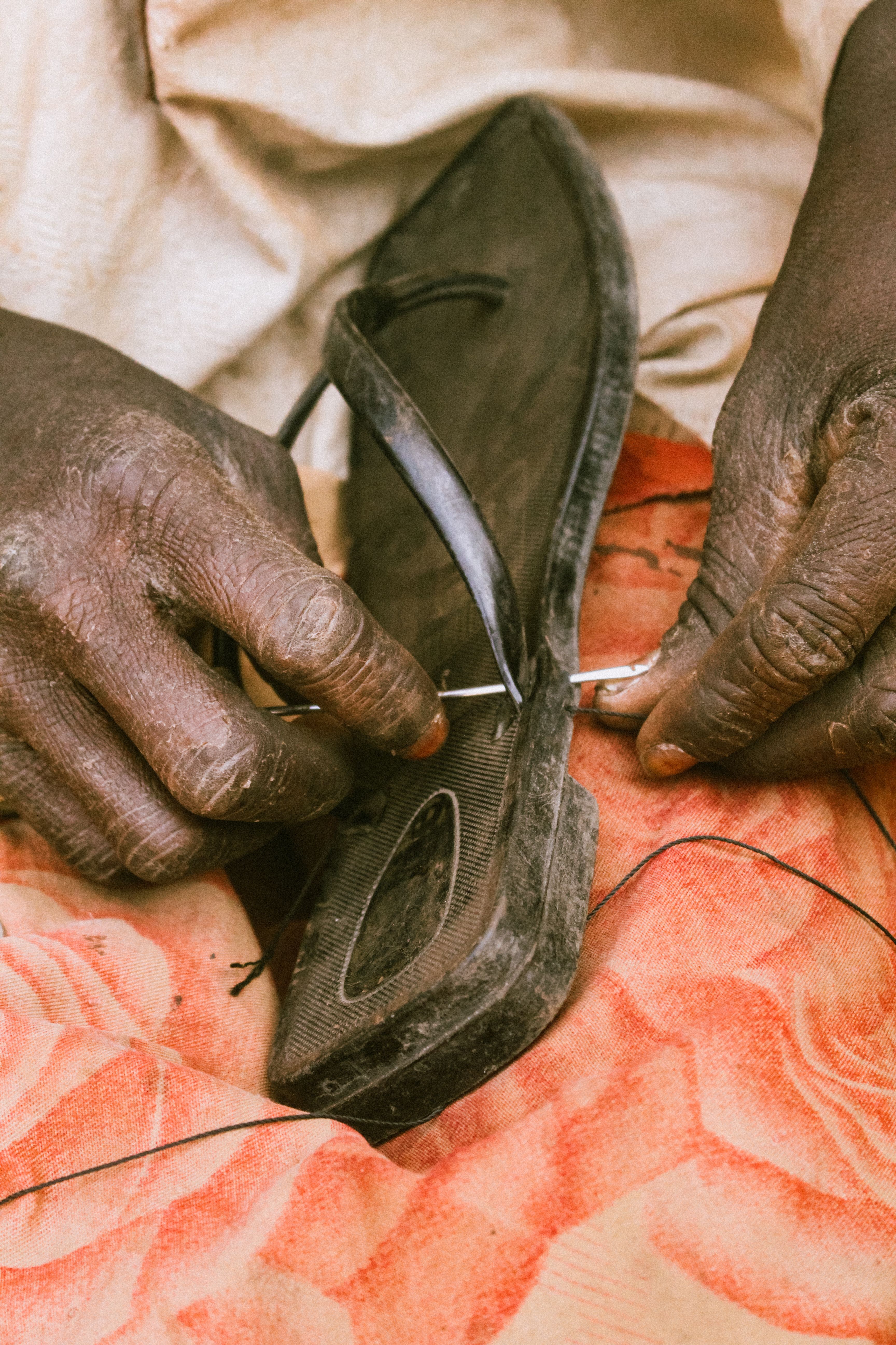 Hausa cobbler skillfully repairs footwear in Enugu