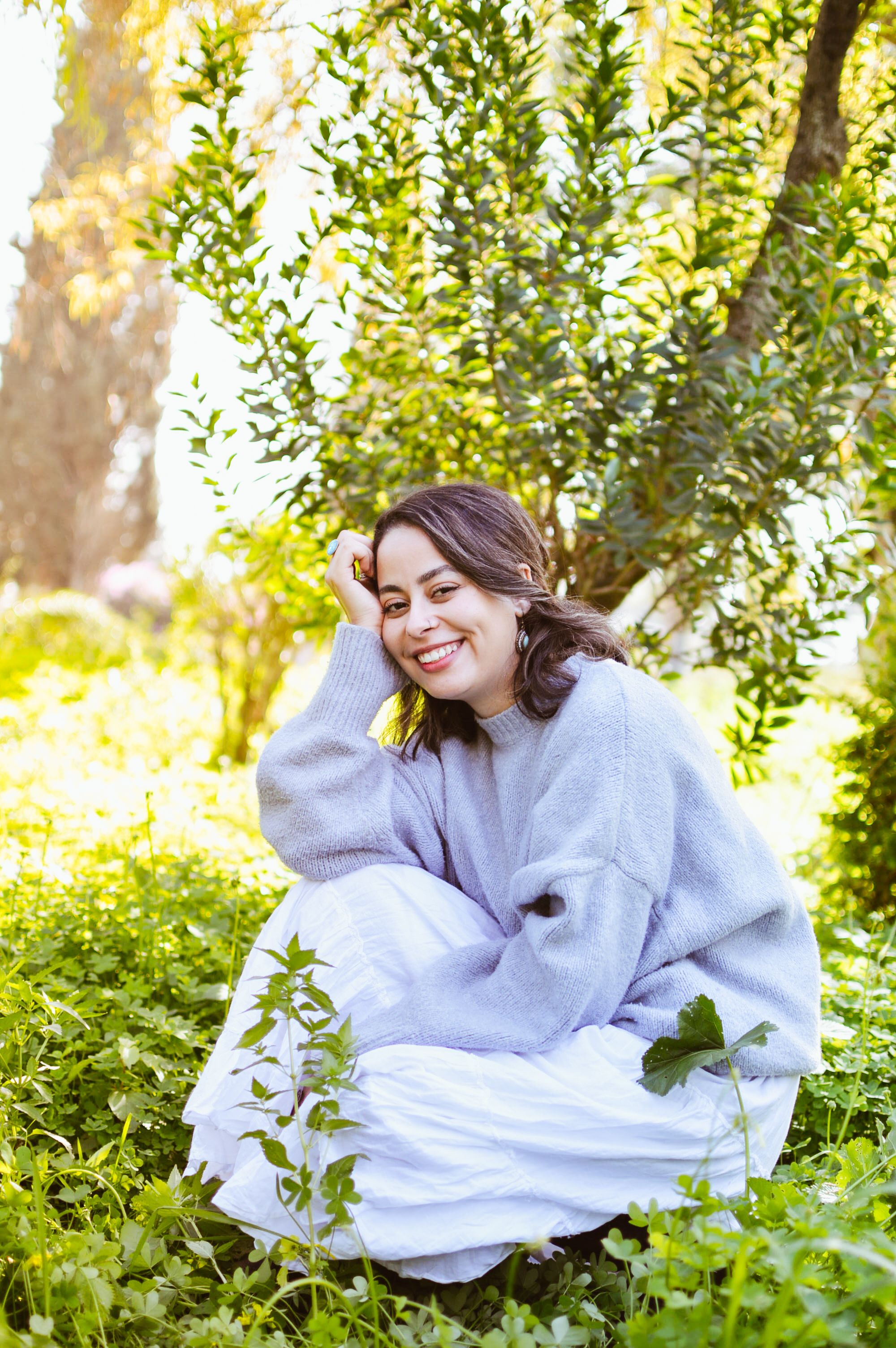 Woman relaxing under tree in sunny spring garden · Free Stock Photo