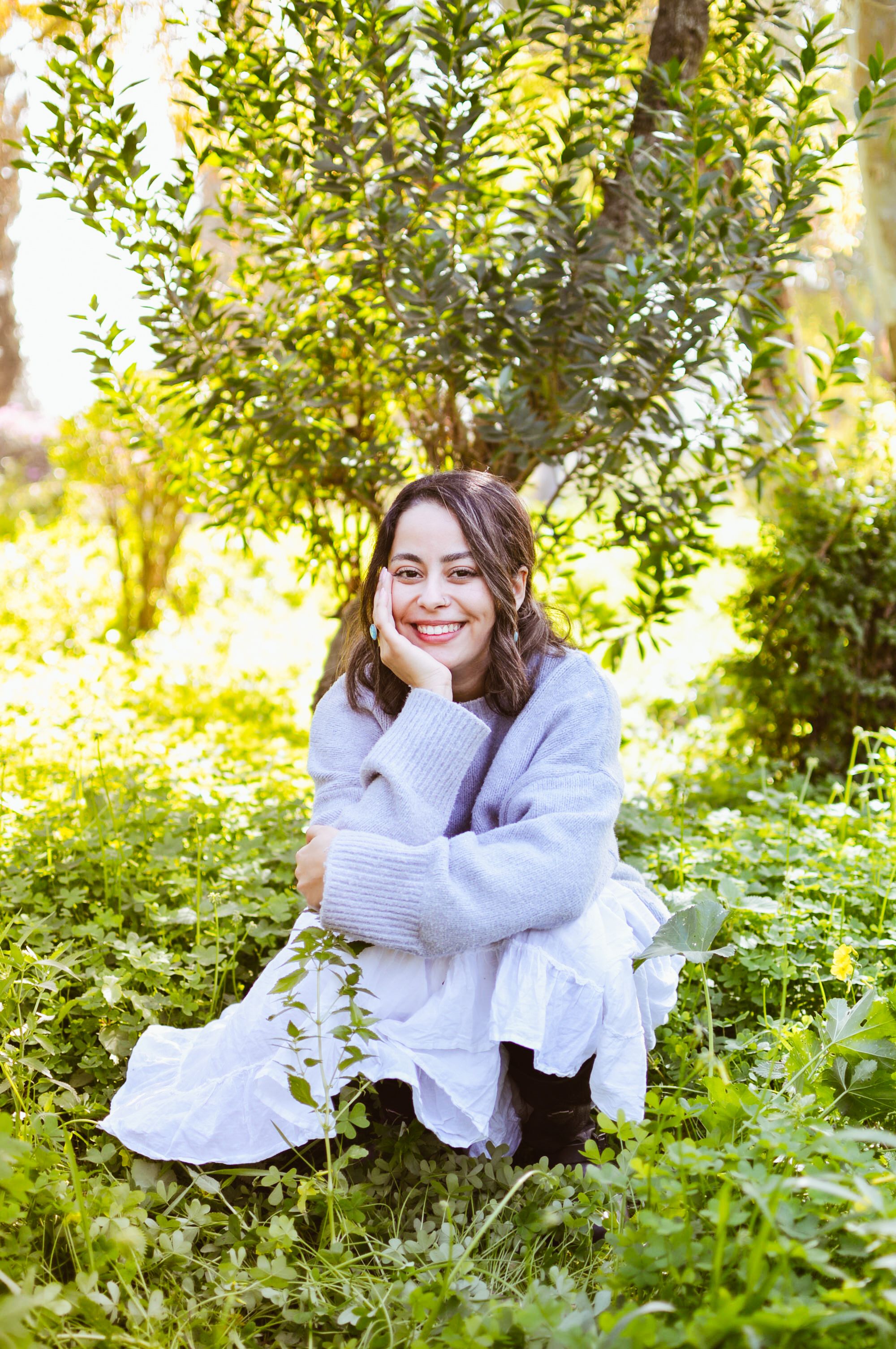 Woman relaxing under tree in sunny spring garden · Free Stock Photo