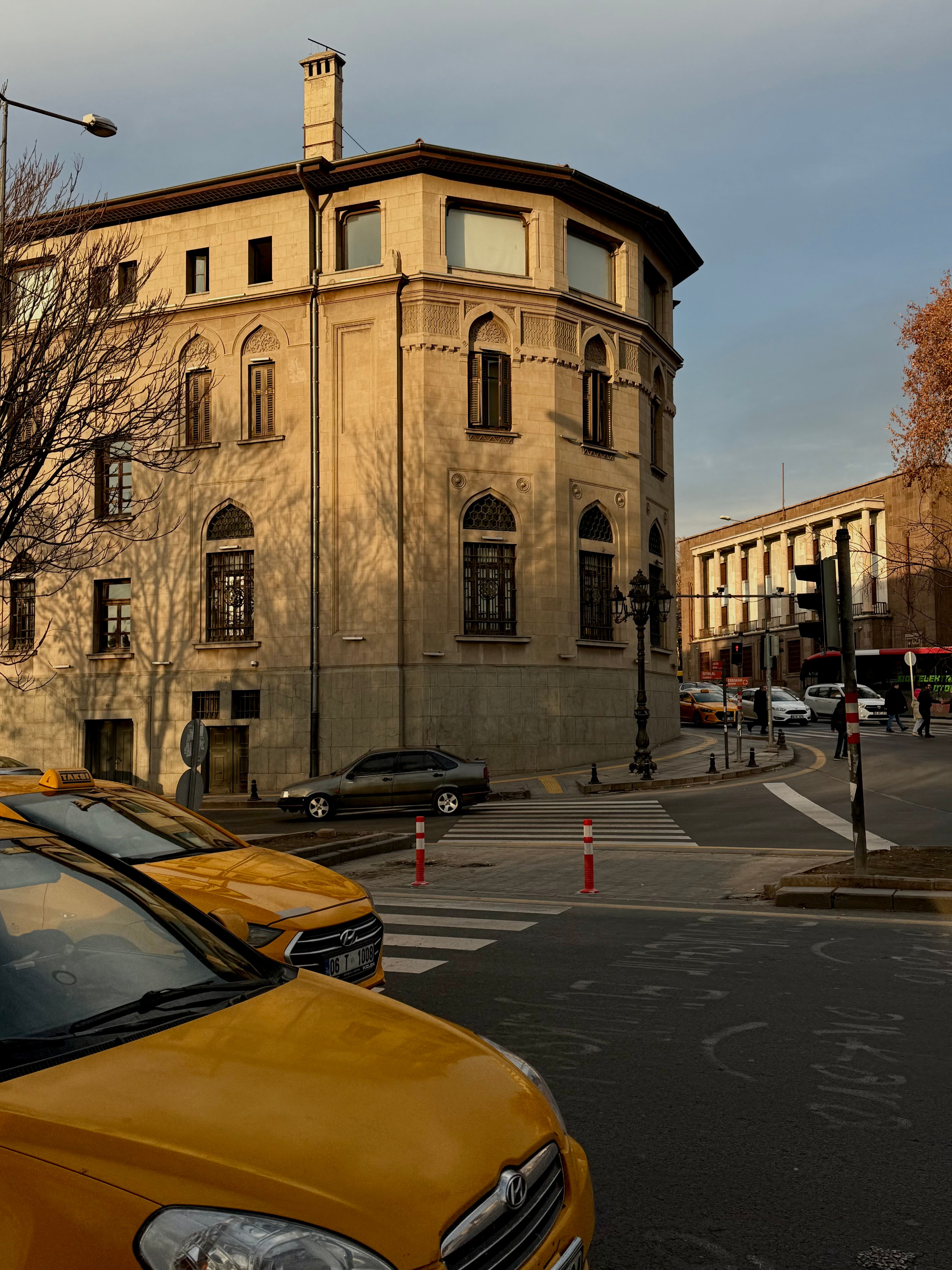 Charming urban scene with historic buildings and yellow taxis on a quiet street corner at dusk.