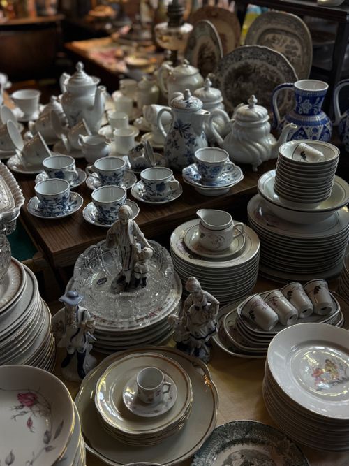 Free A collection of vintage porcelain teacups and dinnerware in a cozy antique shop. Stock Photo