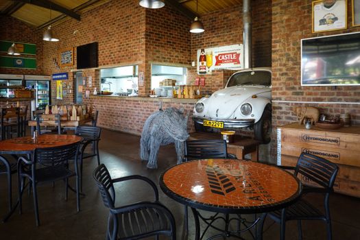 Cozy restaurant interior featuring a vintage car, rustic decor, and ambient lighting.