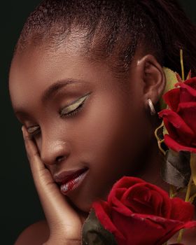 Close-up portrait of an African woman with closed eyes and roses.