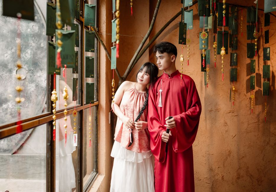 A couple poses in traditional Vietnamese attire amidst lanterns in Hội An, capturing cultural essence.
