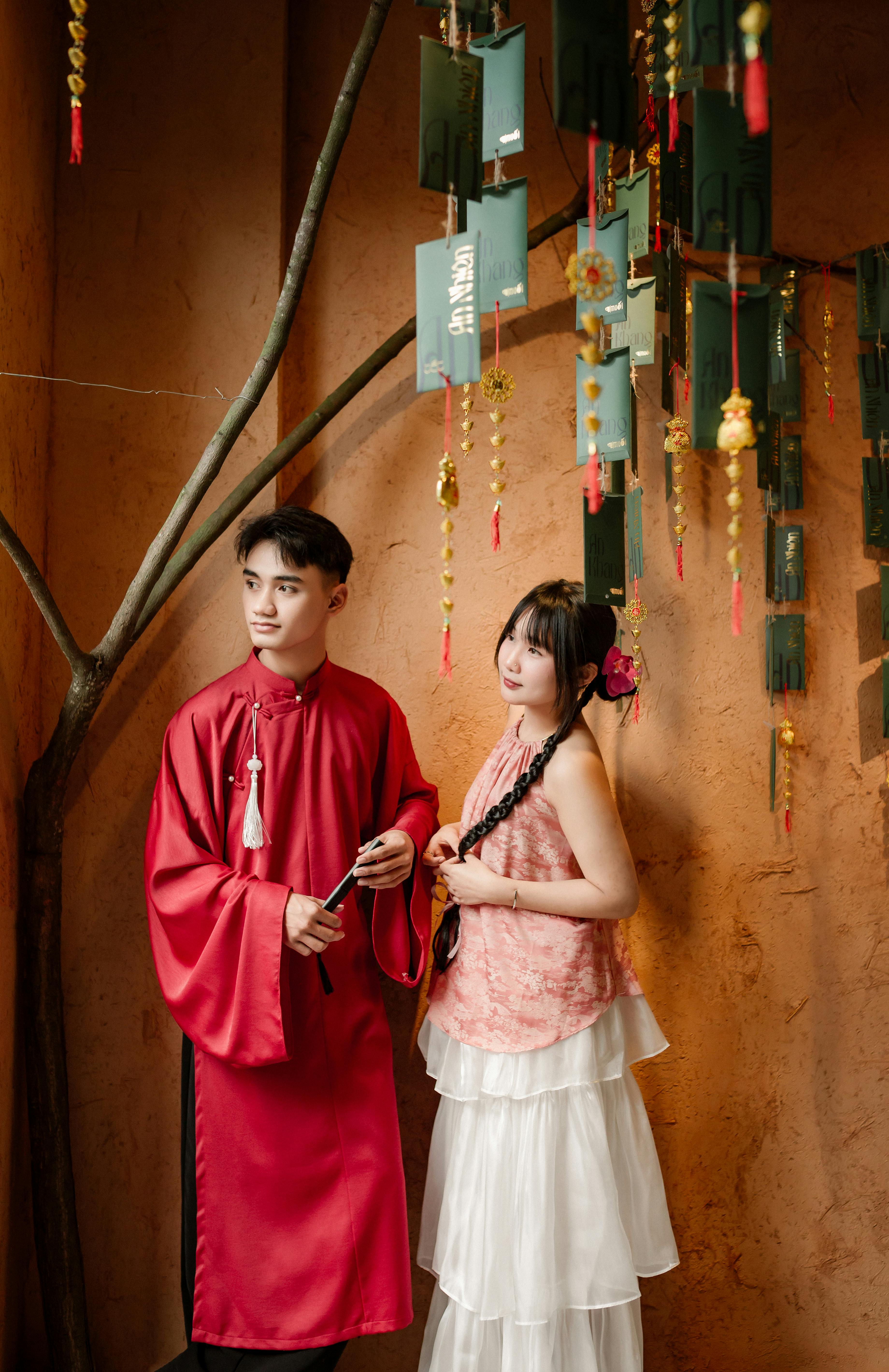 Couple in traditional Ao Dai pose in Hội An, showcasing cultural heritage.