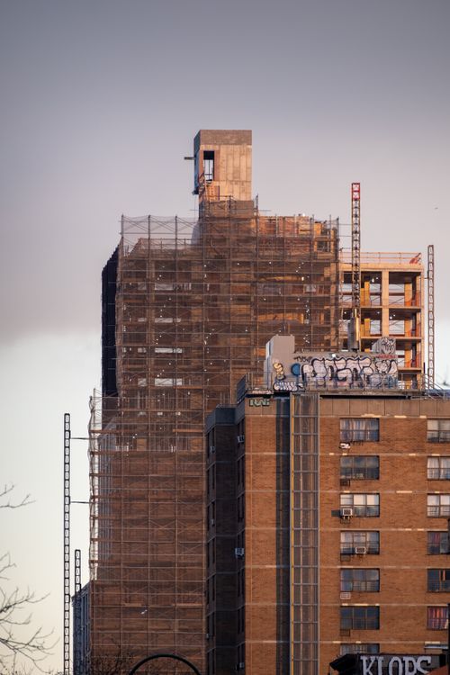 Free Scaffolding and cranes at an NYC construction site during golden hour, showcasing urban renewal. Stock Photo