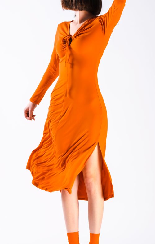 Free Flowing orange dress captured in artistic motion, showcasing elegance and fluidity. Stock Photo