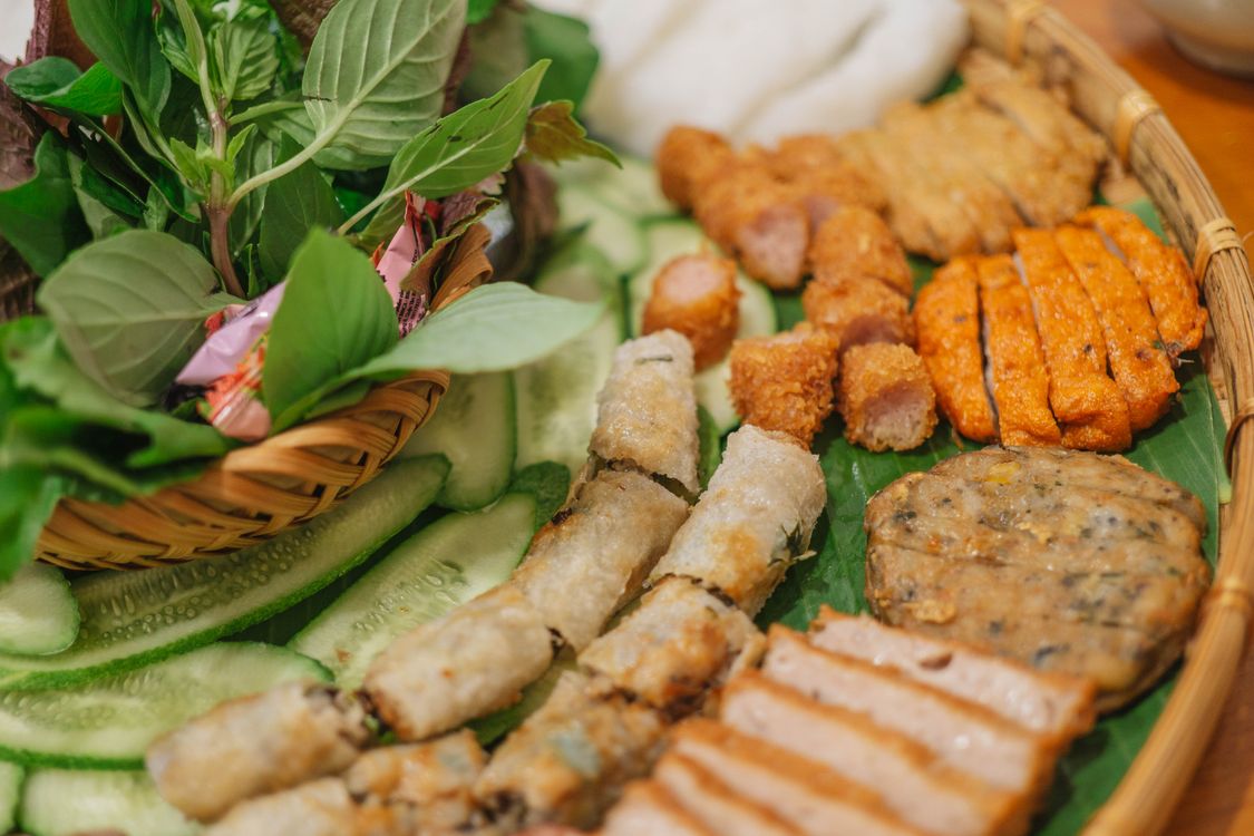 Miễn phí Một đĩa thức ăn Việt Nam đầy màu sắc với các loại thảo mộc tươi, chả giò và thịt nướng. Ảnh lưu trữ