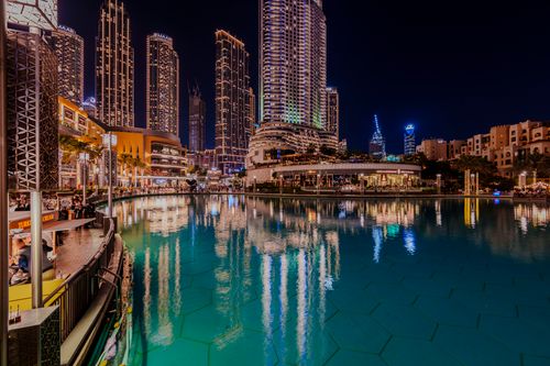 Free Captivating night view of Dubai's cosmopolitan skyline reflecting in a serene pond. Stock Photo