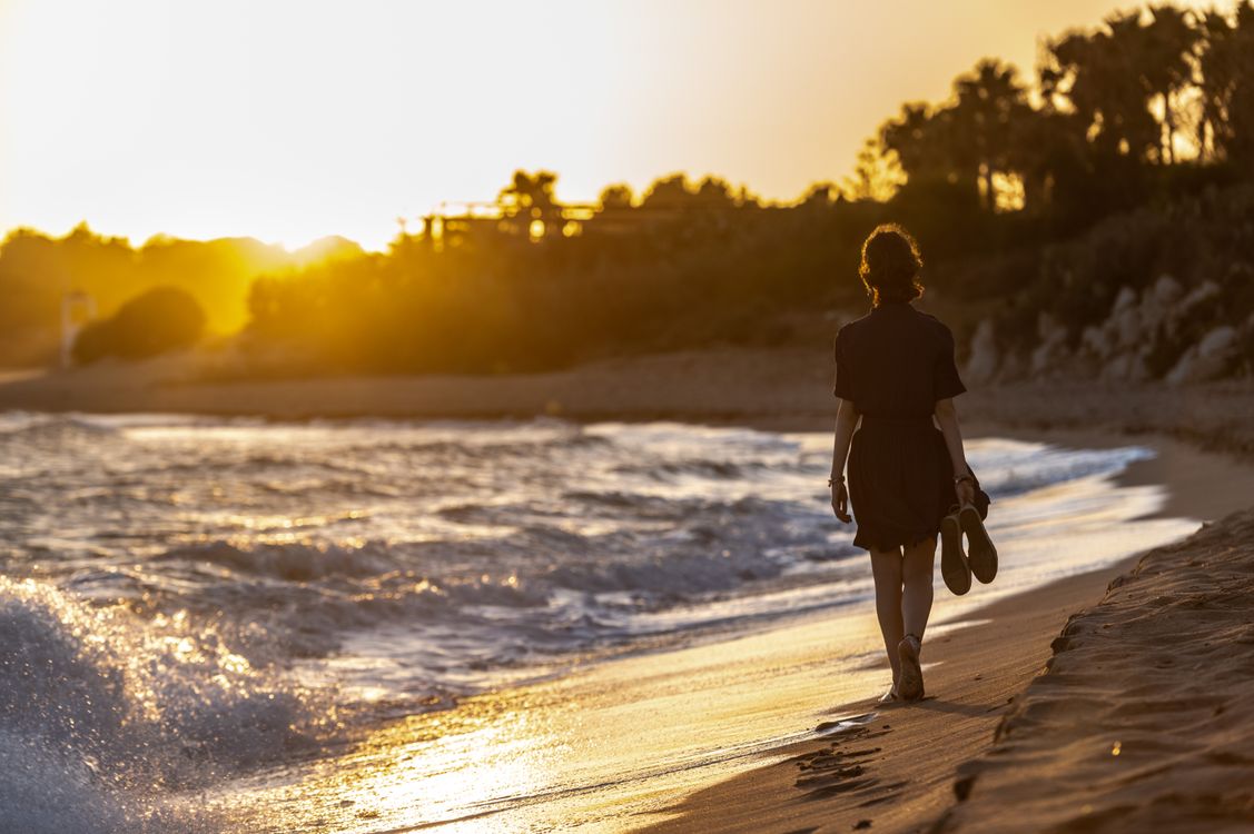 Woman Walking Barefoot on Beach at Sunset · Free Stock Photo