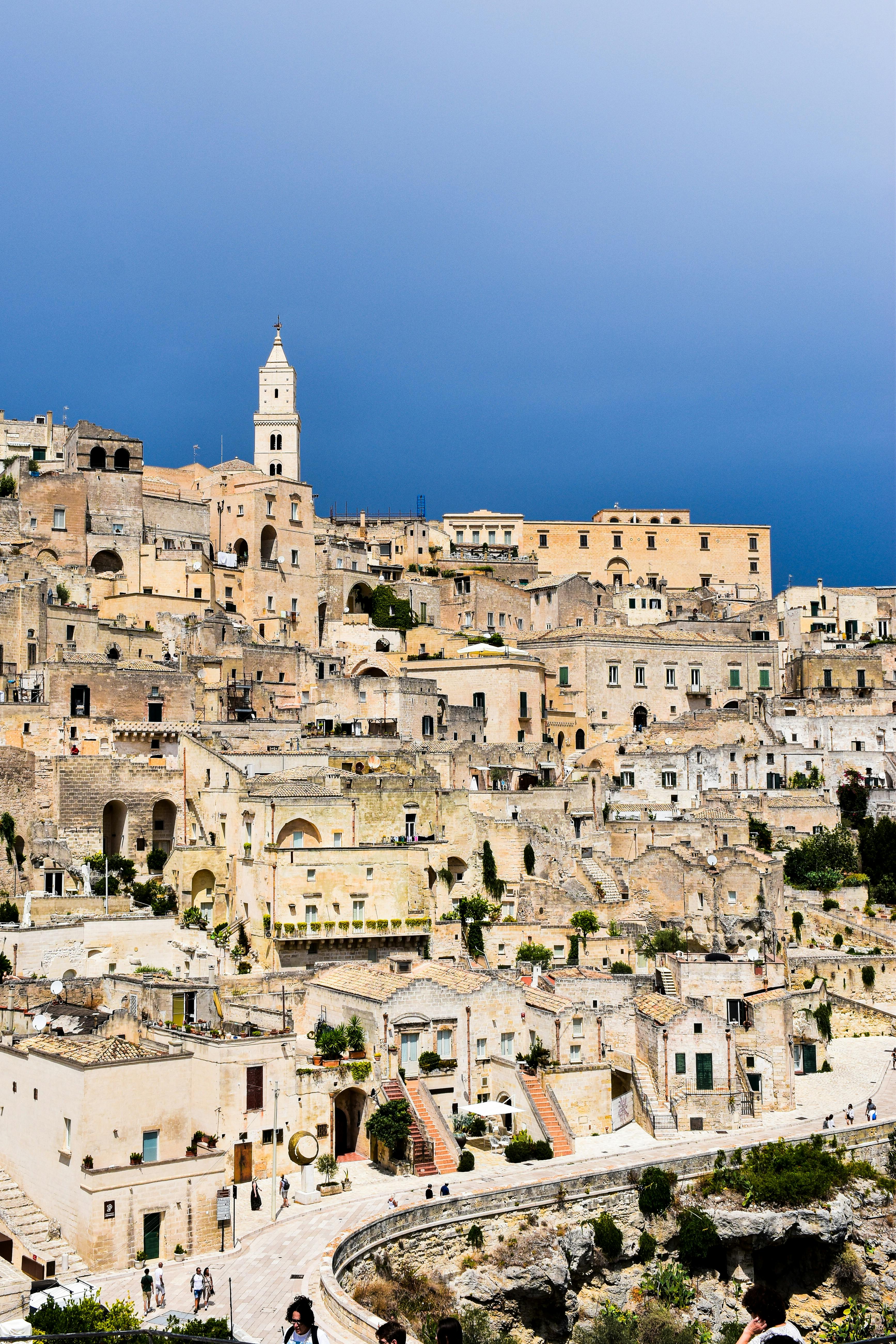 Scenic view of ancient stone architecture in Matera, Apulia, Italy, under a vibrant sky.