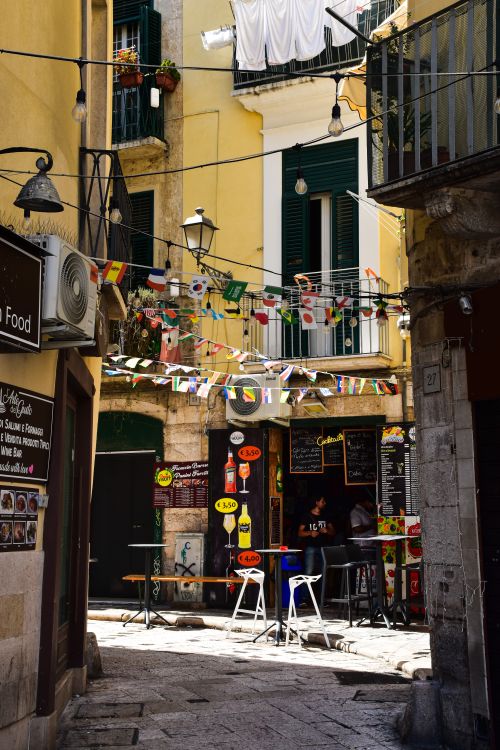 Free Charming street scene with a cozy café in Bari, Italy's Apulia region. Perfect for travelers. Stock Photo