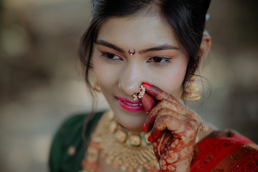 Close-up of a bride with intricate henna, jewelry, and traditional attire, showcasing cultural beauty.