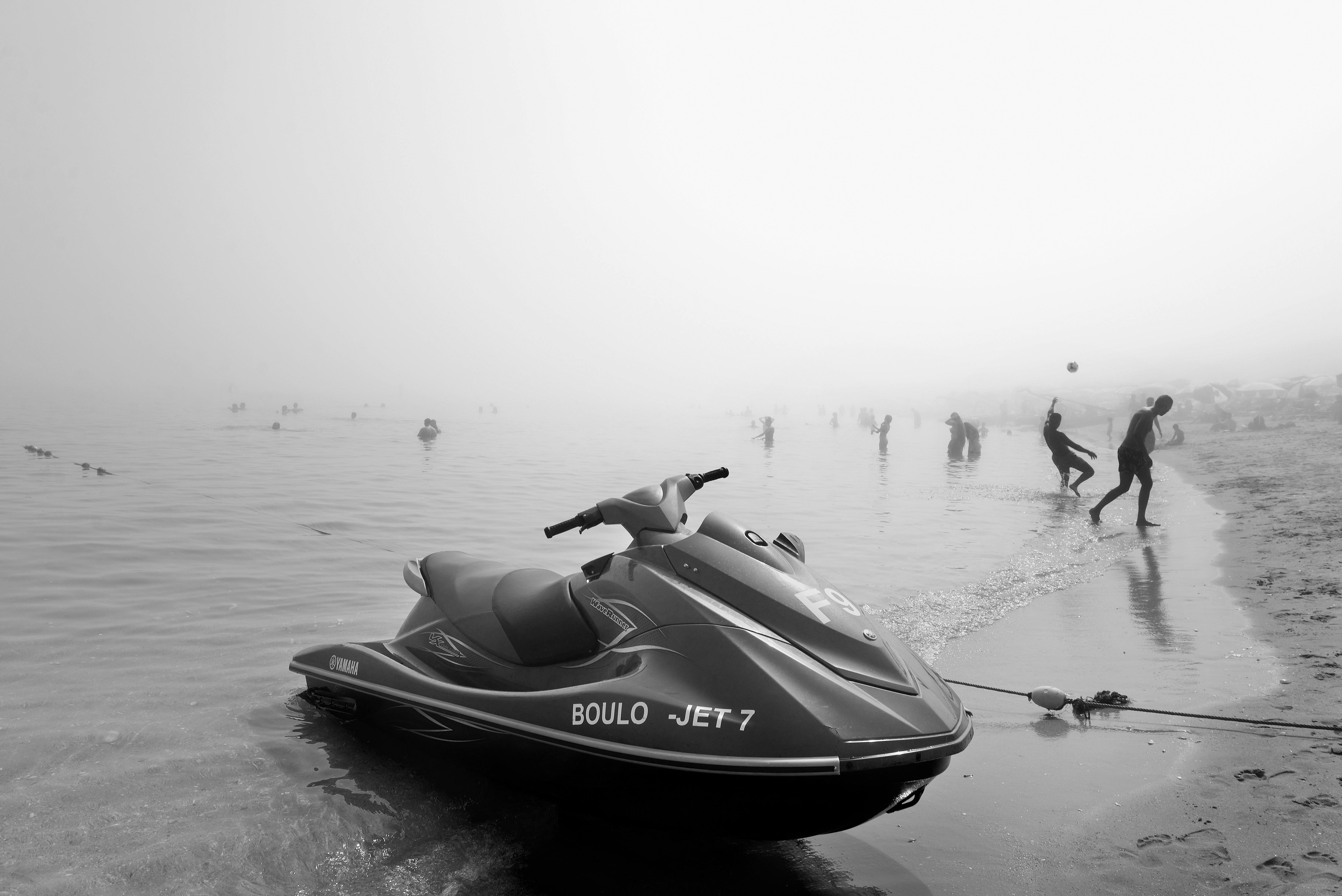 Une scène de plage brumeuse à Tétouan, au Maroc, avec un jet ski et des plagistes profitant de la journée brumeuse. 