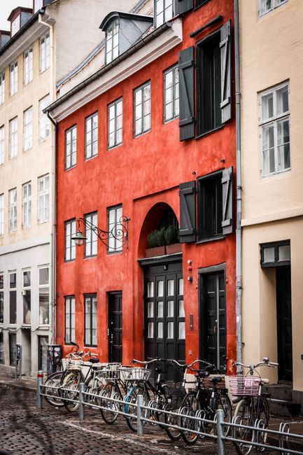 Charming Copenhagen street with bicycles against colorful buildings.