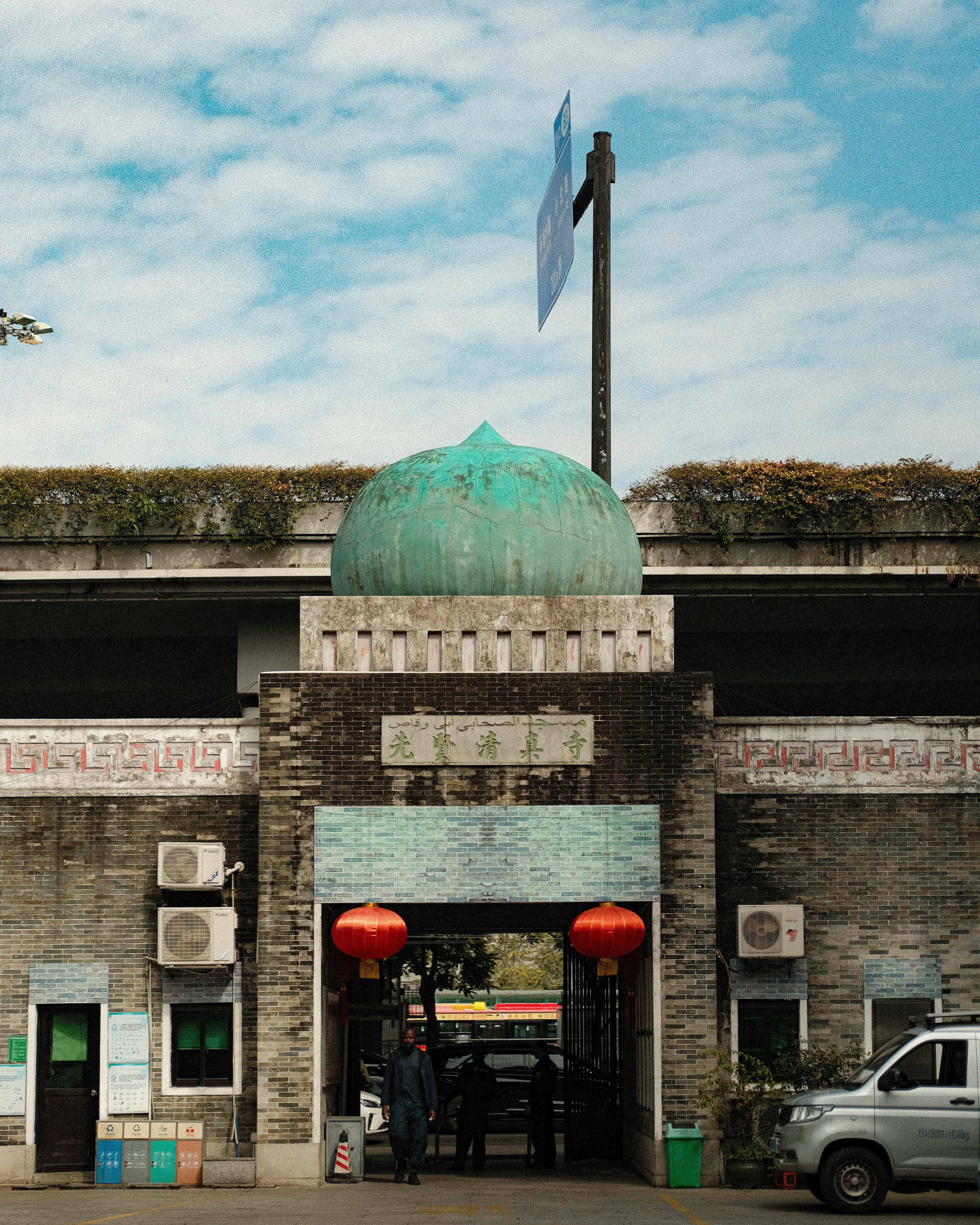Entrance to traditional Chinese building with red lanterns and distinctive architecture.