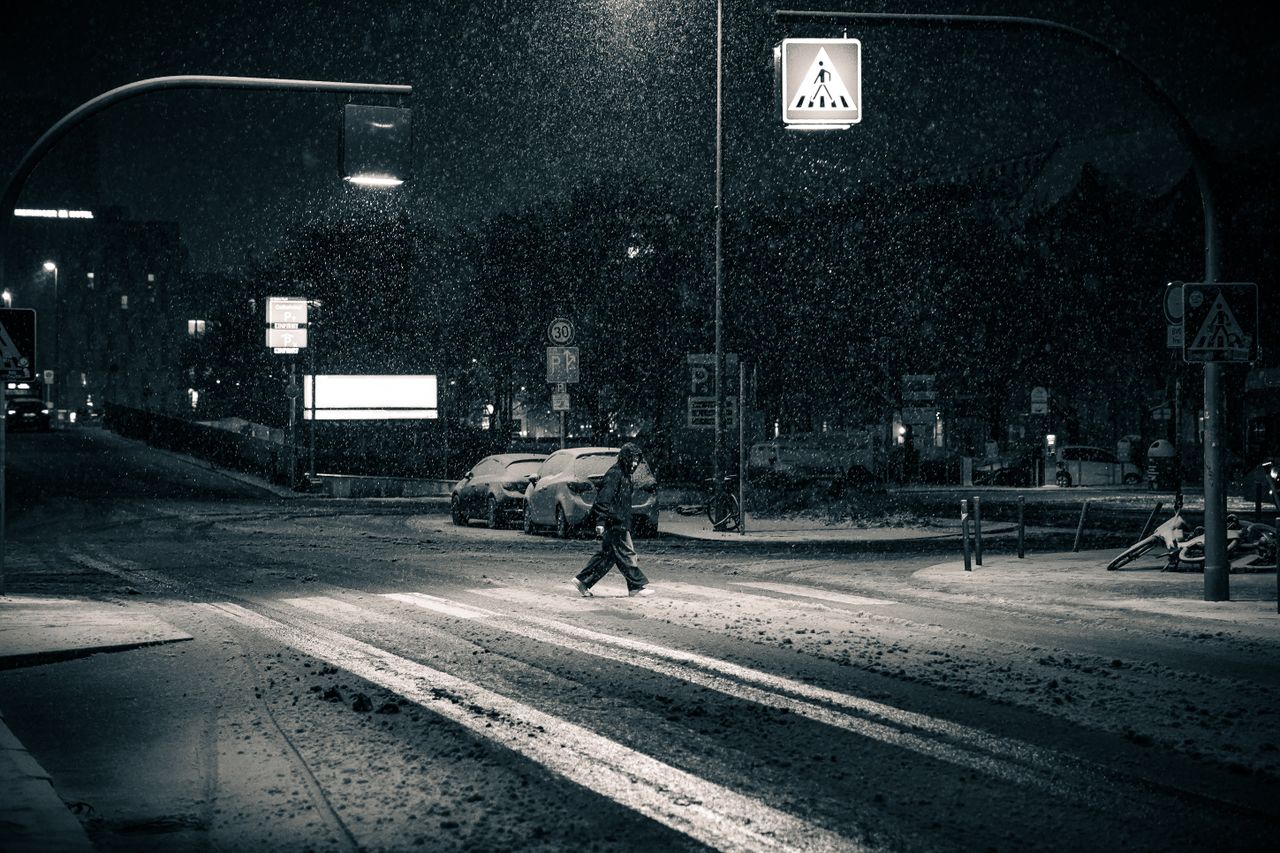 a moody and atmospheric snowy street scene in berlin at night