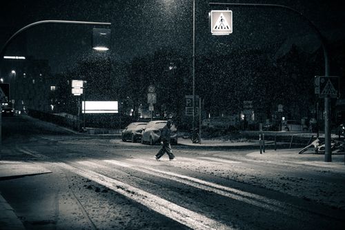 Free A moody and atmospheric snowy street scene in Berlin at night. Stock Photo